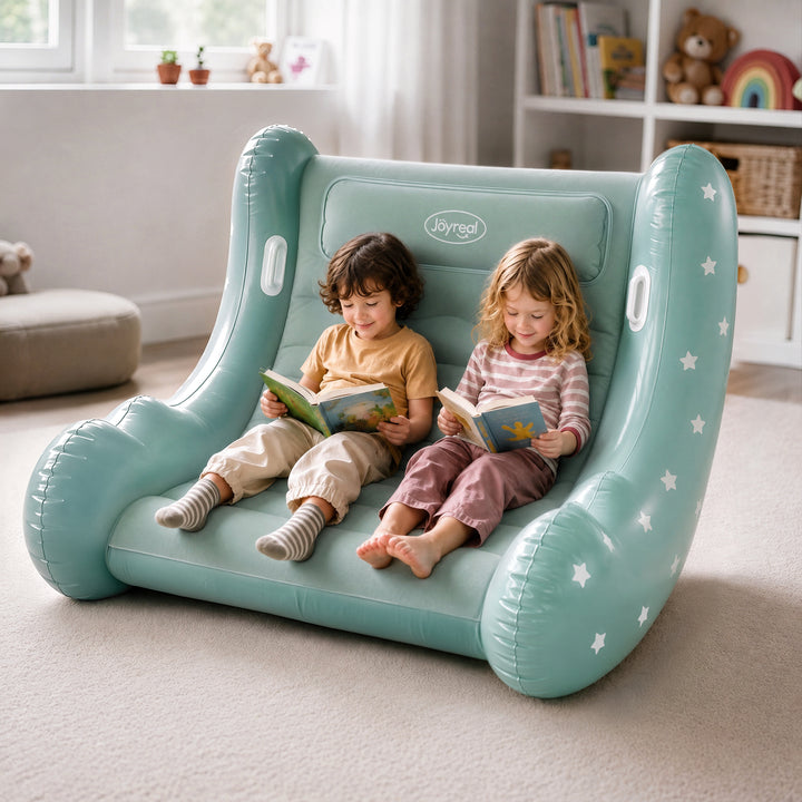 Two children sitting on a mint green inflatable lounge chair with white star details, reading books in a bright, modern room. The brand name &