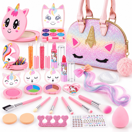 A children's unicorn-themed makeup and accessory set arranged on a white background, including a glittery unicorn-face handbag, makeup palettes, lip glosses, brushes, sponges, stickers, and small pink accessories.