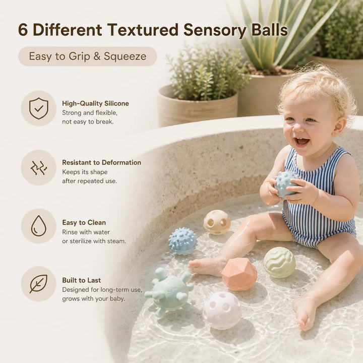Baby squeezing textured silicone sensory balls during bath play