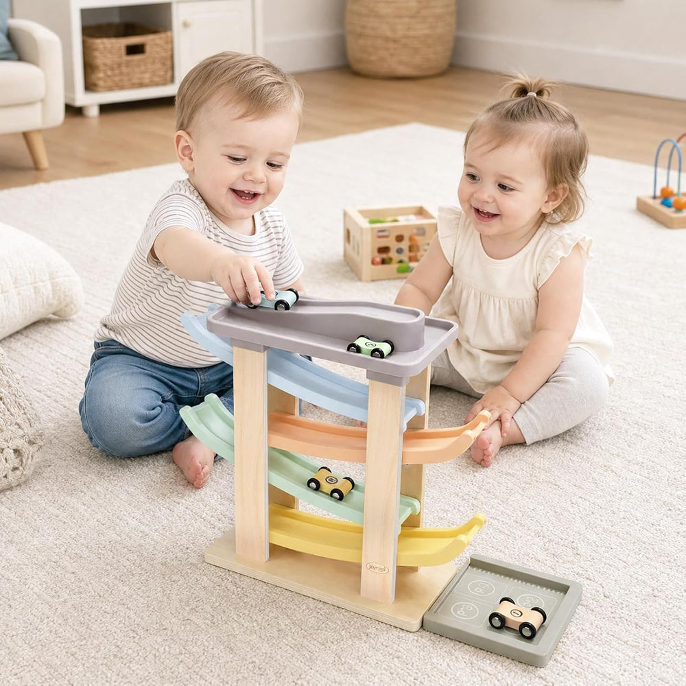 Toddler playing with a wooden four-car ramp racer