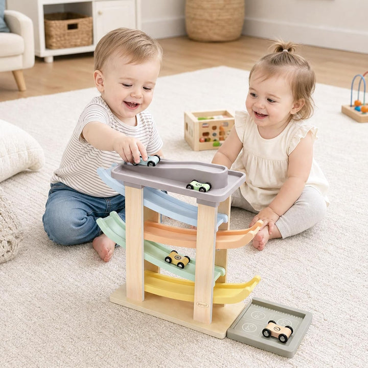 Toddler playing with a wooden four-car ramp racer
