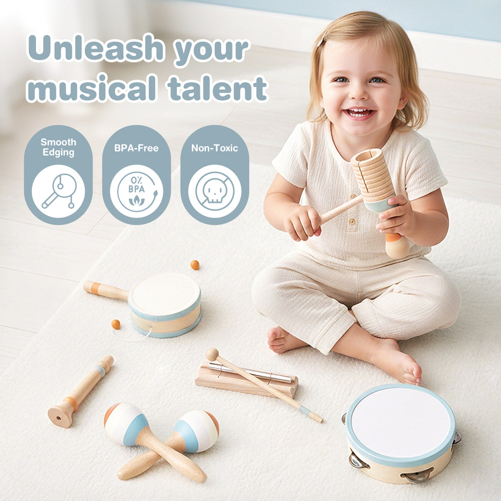 A smiling toddler sits on a white floor playing with a wooden music toy set of tambourines, maracas, and small percussion instruments.